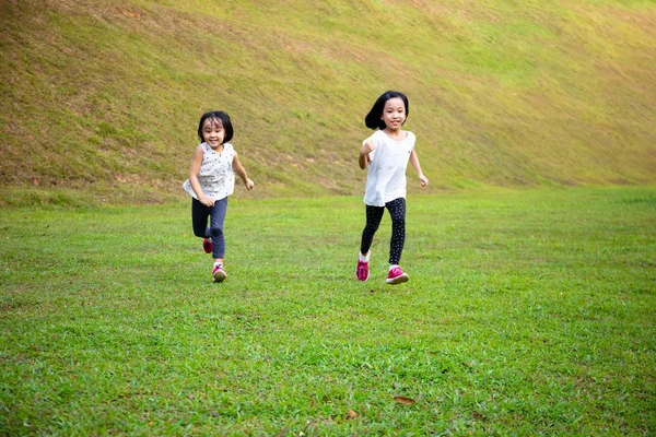 Asiatische kleine chinesische Schwestern laufen glücklich Stockbild