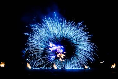 Karanlık bir gökyüzüne ve fırtınalara karşı bir ateş gösterisinin ateşli parçaları.