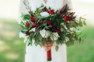 düğün buket kırmızı çiçek ve yeşillik gelinin elinde
