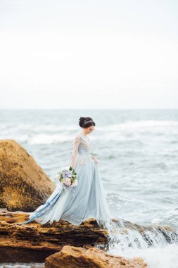 bir buket çiçek sahilde gelinle
