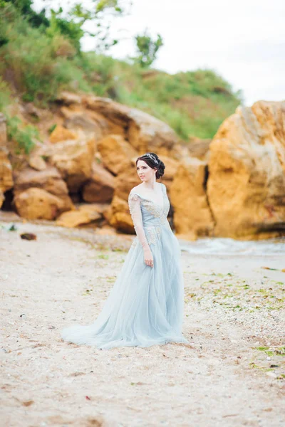 Sposa in un abito blu chiaro passeggiando lungo l'oceano — Foto Stock