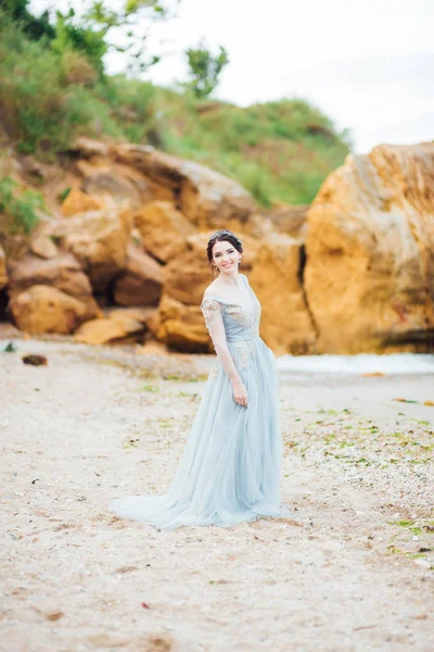 Sposa in un abito blu chiaro passeggiando lungo l'oceano — Foto Stock