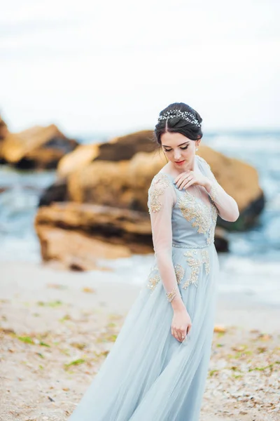 Sposa in un abito blu chiaro passeggiando lungo l'oceano — Foto Stock