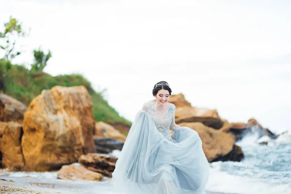 Sposa in un abito blu chiaro passeggiando lungo l'oceano — Foto Stock