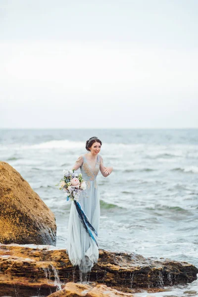 Νύφη με ένα μπουκέτο από λουλούδια στην παραλία — Φωτογραφία Αρχείου