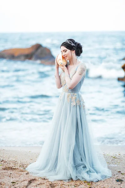 Sposa con una grande conchiglia sulla spiaggia — Foto Stock