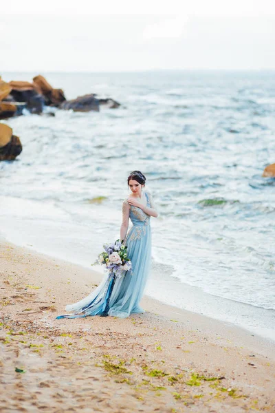 Νύφη με ένα μπουκέτο από λουλούδια στην παραλία — Φωτογραφία Αρχείου