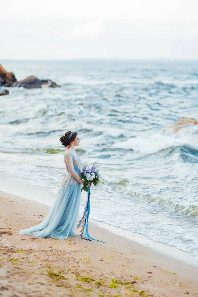 Sposa con un mazzo di fiori sulla spiaggia — Foto Stock