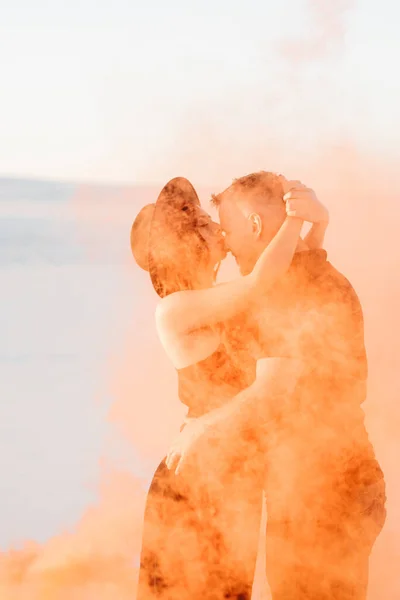 Siyah Elbiseli Bir Adam Bir Kız Turuncu Dumanla Beyaz Kumda — Stok fotoğraf