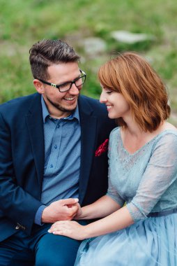 Genç bir çift göl kenarında yürüyüş yapıyor. Etrafı Karpat dağlarıyla çevrili.