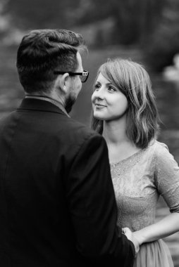 Genç bir çift göl kenarında yürüyüş yapıyor. Etrafı Karpat dağlarıyla çevrili.