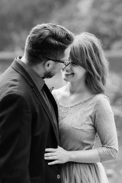 Genç bir çift göl kenarında yürüyüş yapıyor. Etrafı Karpat dağlarıyla çevrili.