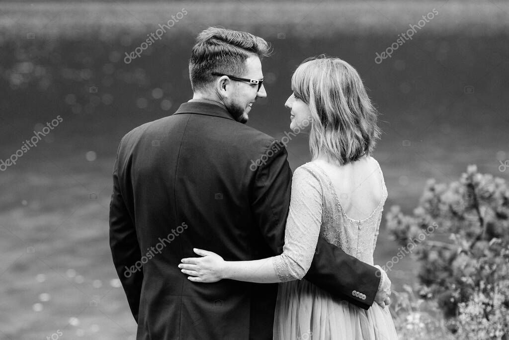 Young couple on a walk near the lake surrounded by the Carpathian mountains