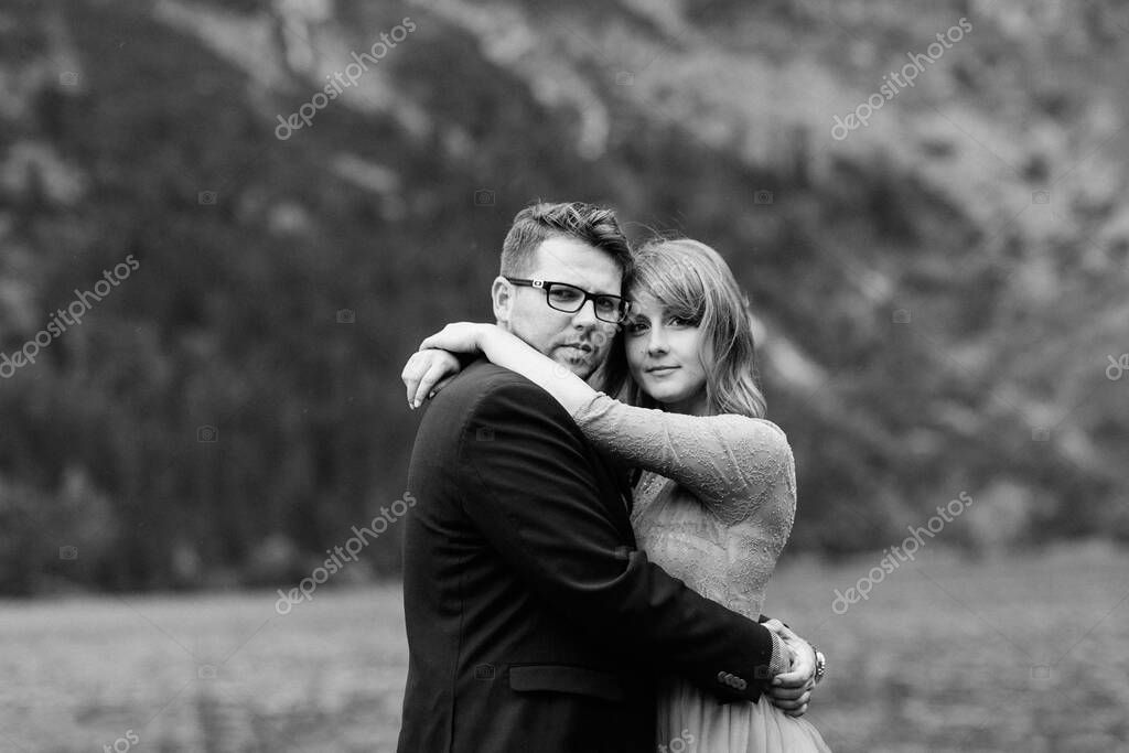 Young couple on a walk near the lake surrounded by the Carpathian mountains