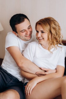 Genç çift sabah gelin ve damat bir otel odasında birlikte günün tadını çıkarıyorlar.