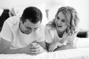 Genç çift sabah gelin ve damat bir otel odasında birlikte günün tadını çıkarıyorlar.