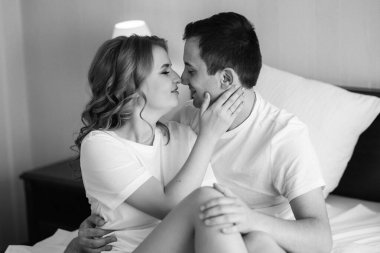 Genç çift sabah gelin ve damat bir otel odasında birlikte günün tadını çıkarıyorlar.