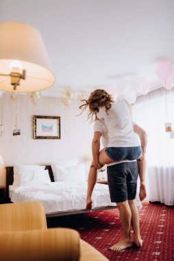 Genç çift sabah gelin ve damat bir otel odasında birlikte günün tadını çıkarıyorlar.