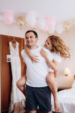 Genç çift sabah gelin ve damat bir otel odasında birlikte günün tadını çıkarıyorlar.