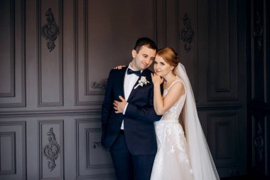 Genç bir çift karanlık bir stüdyoda, bir ayna ve bir avizeyle.