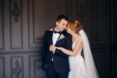 Genç bir çift karanlık bir stüdyoda, bir ayna ve bir avizeyle.