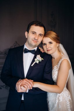 Genç bir çift karanlık bir stüdyoda, bir ayna ve bir avizeyle.