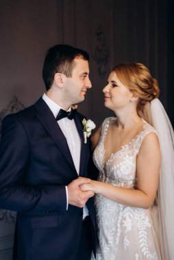 Genç bir çift karanlık bir stüdyoda, bir ayna ve bir avizeyle.