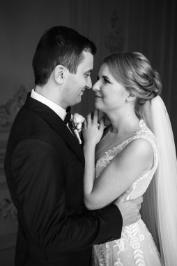 Genç bir çift karanlık bir stüdyoda, bir ayna ve bir avizeyle.