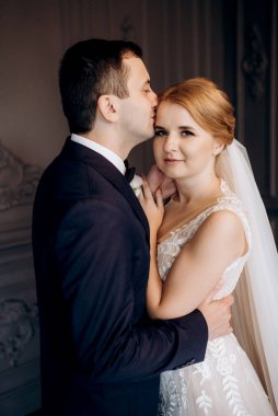 Genç bir çift karanlık bir stüdyoda, bir ayna ve bir avizeyle.