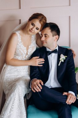 Genç bir çift karanlık bir stüdyoda, bir ayna ve bir avizeyle.