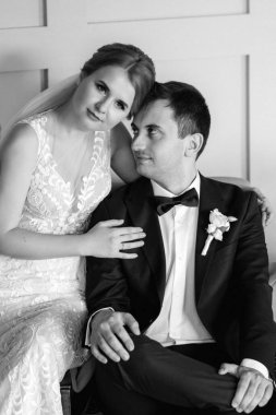 Genç bir çift karanlık bir stüdyoda, bir ayna ve bir avizeyle.