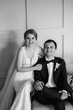 Genç bir çift karanlık bir stüdyoda, bir ayna ve bir avizeyle.