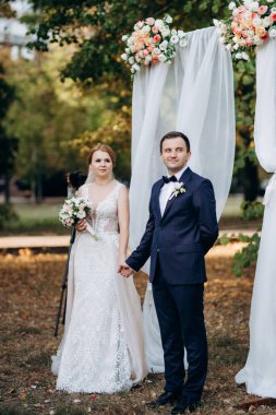 Bir adamla bir kızın düğün seremonisi Orman yolunda bir kemerin arka planına karşı