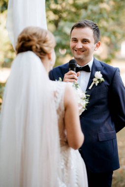 Bir adamla bir kızın düğün seremonisi Orman yolunda bir kemerin arka planına karşı