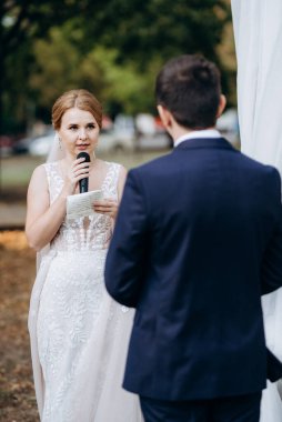 Bir adamla bir kızın düğün seremonisi Orman yolunda bir kemerin arka planına karşı