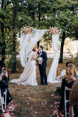 Bir adamla bir kızın düğün seremonisi Orman yolunda bir kemerin arka planına karşı