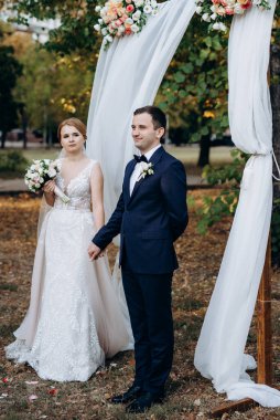 Bir adamla bir kızın düğün seremonisi Orman yolunda bir kemerin arka planına karşı