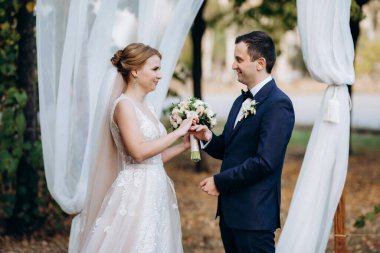 Bir adamla bir kızın düğün seremonisi Orman yolunda bir kemerin arka planına karşı