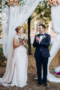 Bir adamla bir kızın düğün seremonisi Orman yolunda bir kemerin arka planına karşı