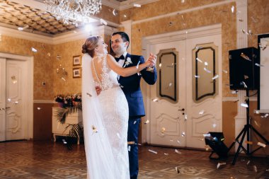 Gelin ve damadın ilk düğün dansı gün batımında restoranın içinde.