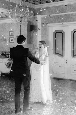 Gelin ve damadın ilk düğün dansı gün batımında restoranın içinde.