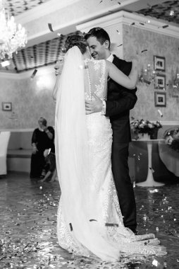 Gelin ve damadın ilk düğün dansı gün batımında restoranın içinde.