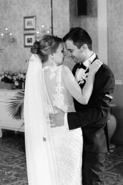 Gelin ve damadın ilk düğün dansı gün batımında restoranın içinde.