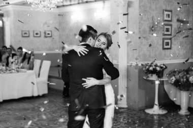 Gelin ve damadın ilk düğün dansı gün batımında restoranın içinde.