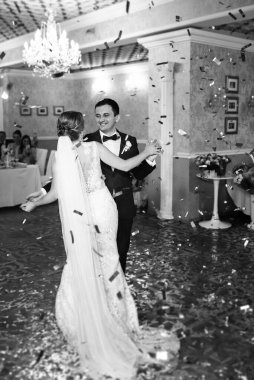 Gelin ve damadın ilk düğün dansı gün batımında restoranın içinde.