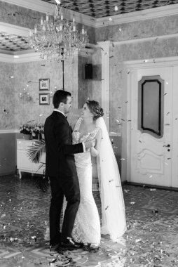 Gelin ve damadın ilk düğün dansı gün batımında restoranın içinde.