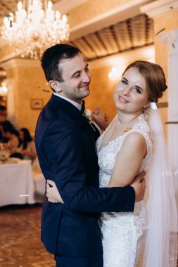 Gelin ve damadın ilk düğün dansı gün batımında restoranın içinde.