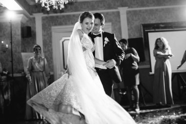 Gelin ve damadın ilk düğün dansı gün batımında restoranın içinde.