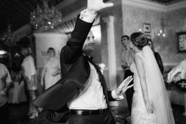 Gelin ve damadın ilk düğün dansı gün batımında restoranın içinde.