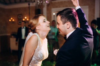 Gelin ve damadın ilk düğün dansı gün batımında restoranın içinde.